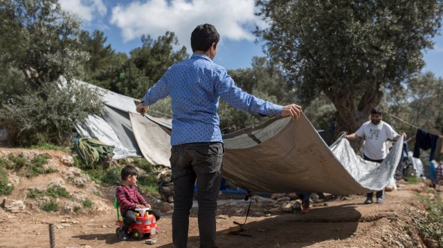 Zwei Afghanen beginnen mit dem Zeltbau. Nicht alle Migranten bekommen ein Zelt, wenn sie ankommen, viele stützen die Planen mit Kartons und Stöcken.