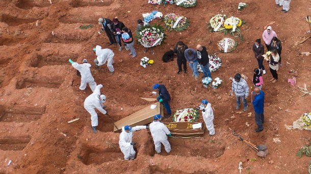 Friedhofsmitarbeiter in Schutzkleidung begraben ein Opfer von Covid-19: In Brasilien steigen die Opferzahlen weiter an. (Quelle: dpa/Andre Penner/AP)